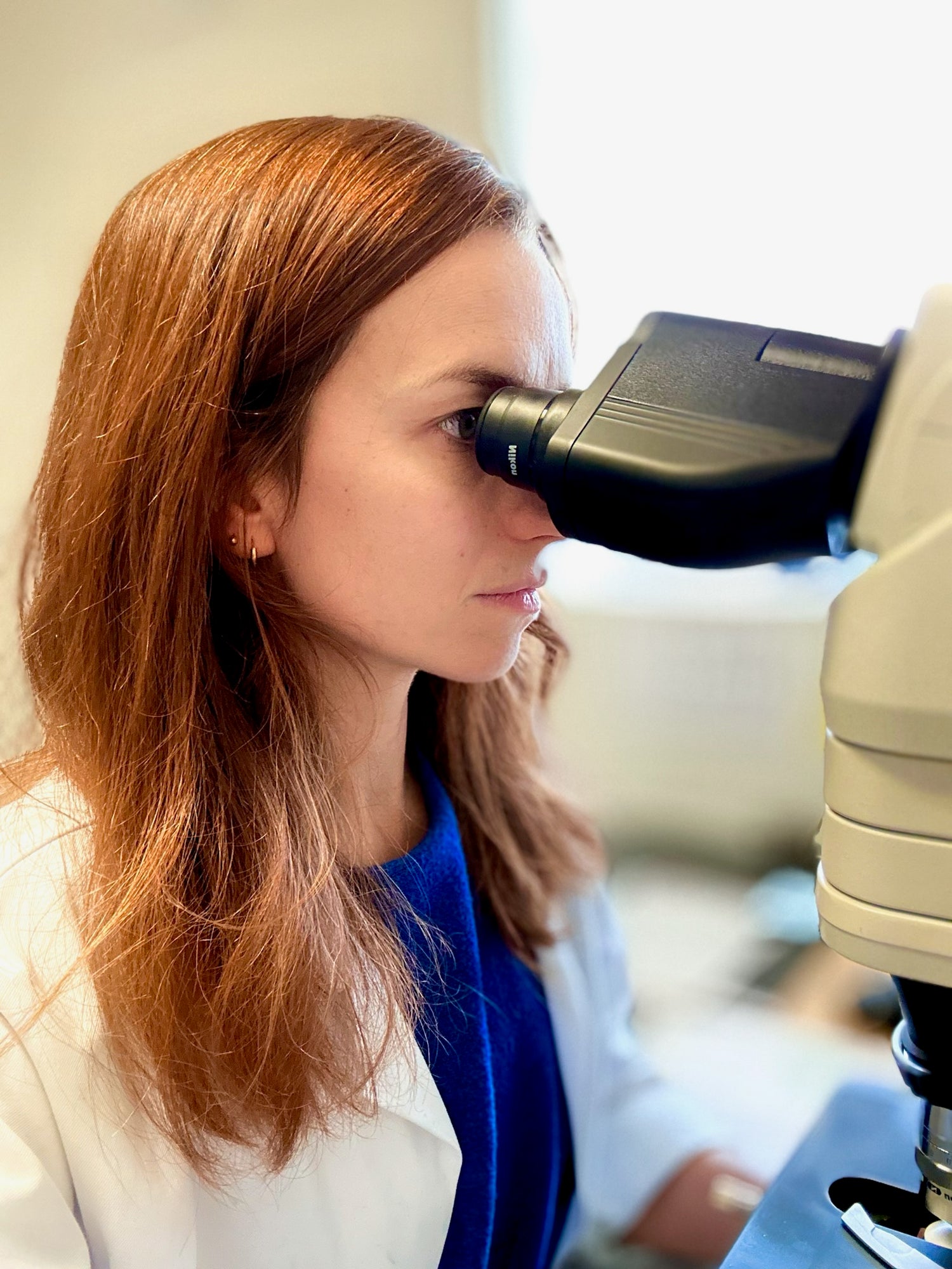 Eilena Braye, artist and pathologist, observing through a microscope — inspiration for her bio-inspired abstract paintings