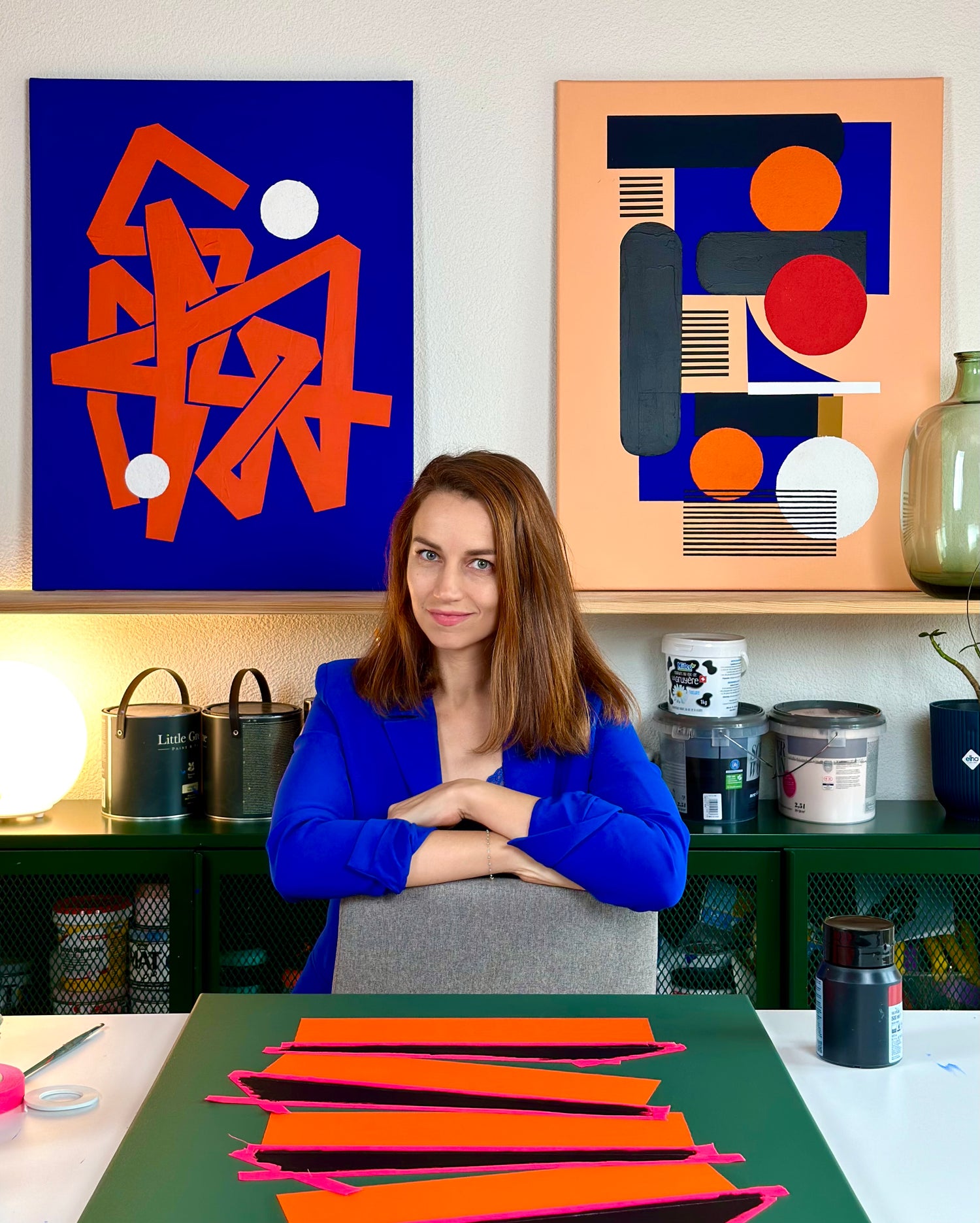Eilena Braye in her art studio, working on abstract paintings inspired by microscopic observation and cellular structures.
